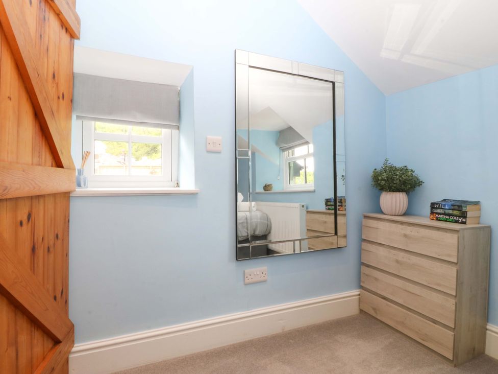 A bedroom with a mirror and a chest of drawers at Old Chapel House Abergwyngregyn near Llanfairfechan