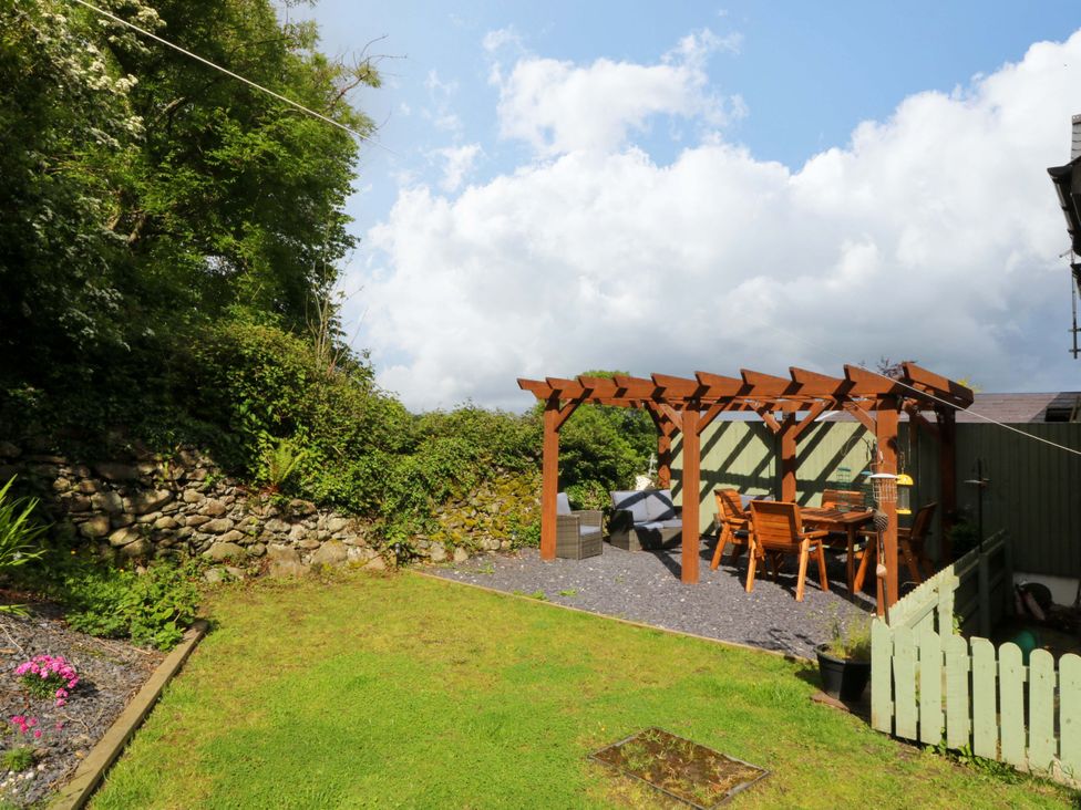 A garden with a pergola and dining area at Old Chapel House Abergwyngregyn near Llanfairfechan