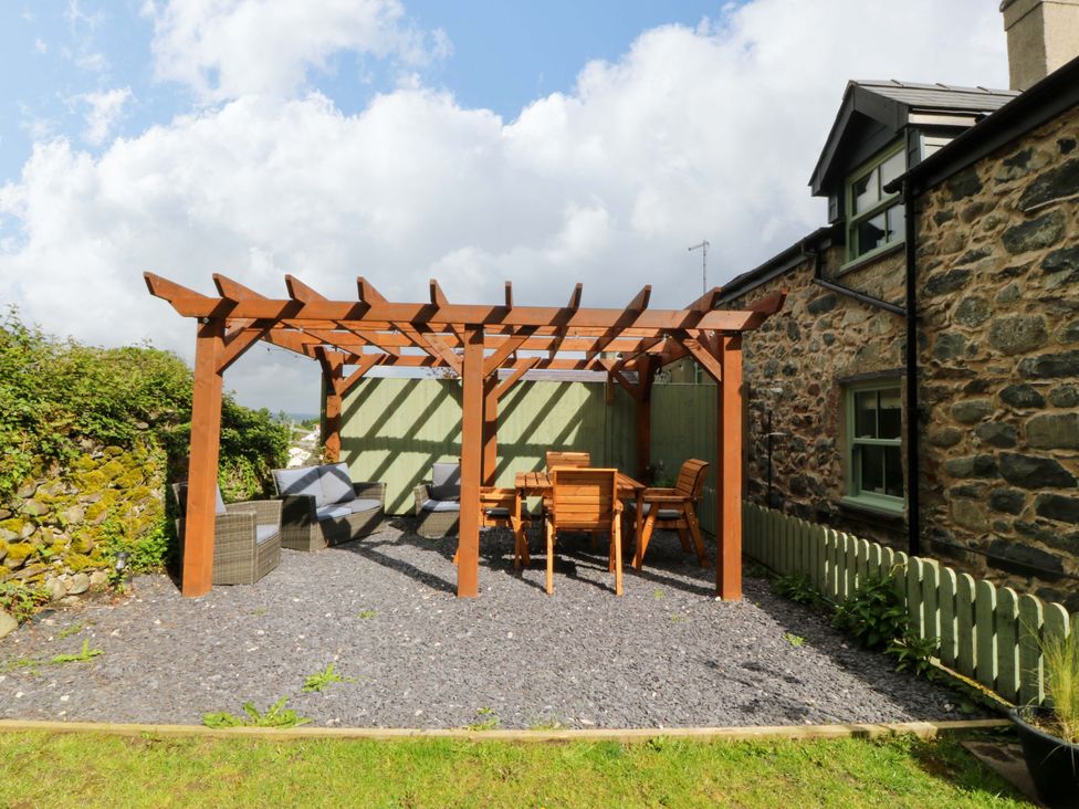 A garden with a pergola and outdoor furniture at Old Chapel House Abergwyngregyn near Llanfairfechan