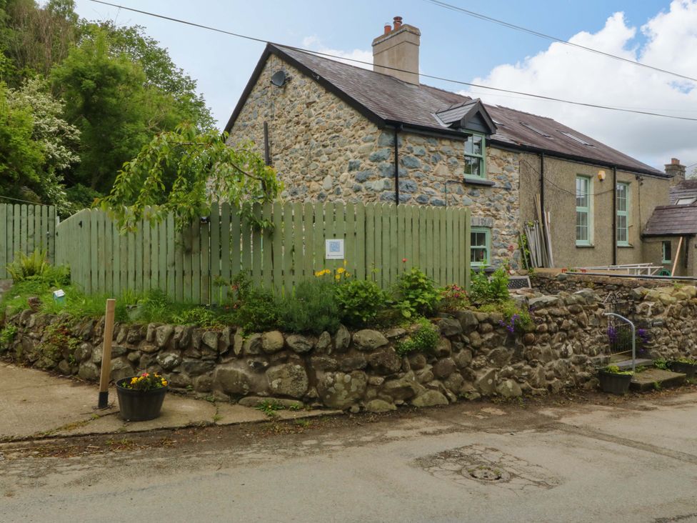 A house with stone wall and green fence at Old Chapel House Abergwyngregyn near Llanfairfechan