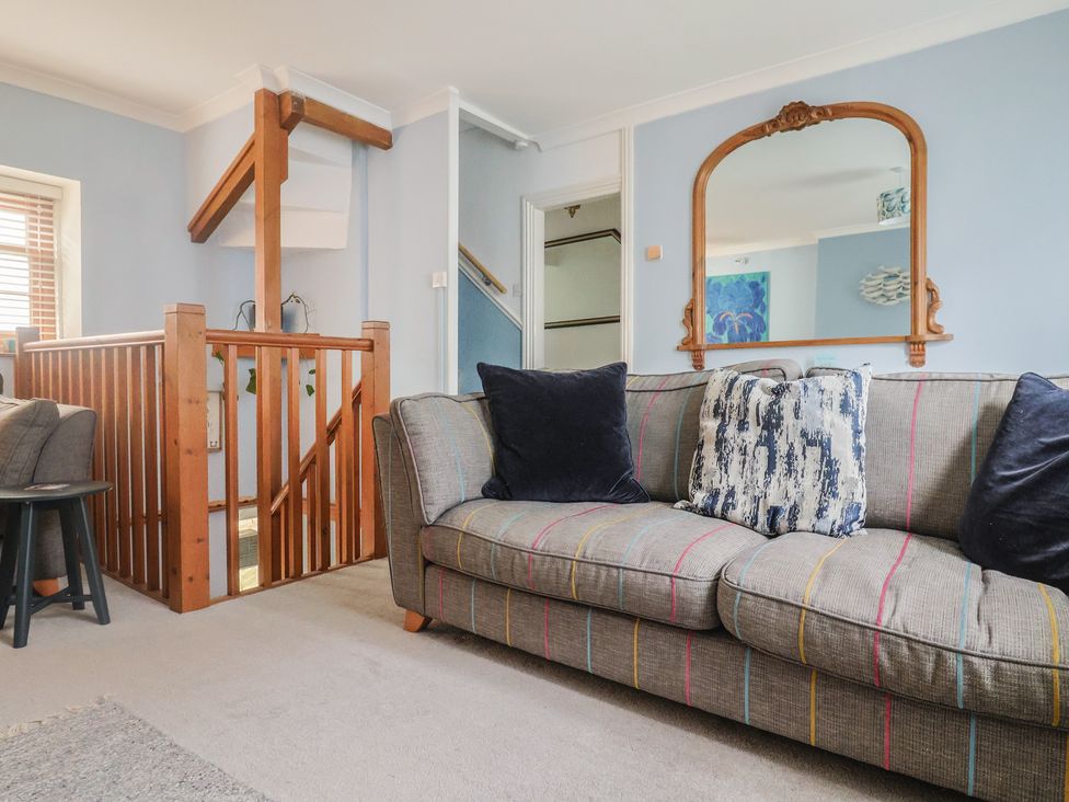 A living room with stairs and sofa at Riverdance Cottage in Lyme Regis