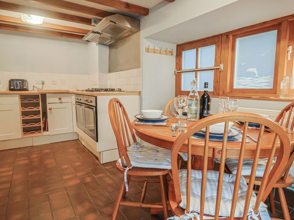 A kitchen with a dining table and chairs at Riverdance Cottage in Lyme Regis