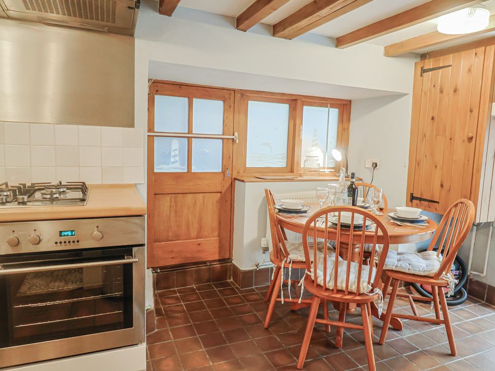 A kitchen with a dining table and chairs at Riverdance Cottage in Lyme Regis