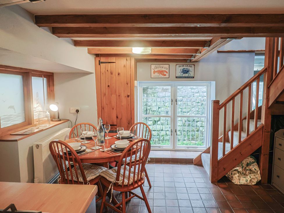 A dining area with a table and chairs at Riverdance Cottage in Lyme Regis
