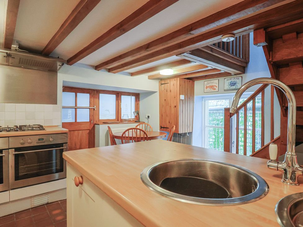 A kitchen with a stove and sink at Riverdance Cottage in Lyme Regis