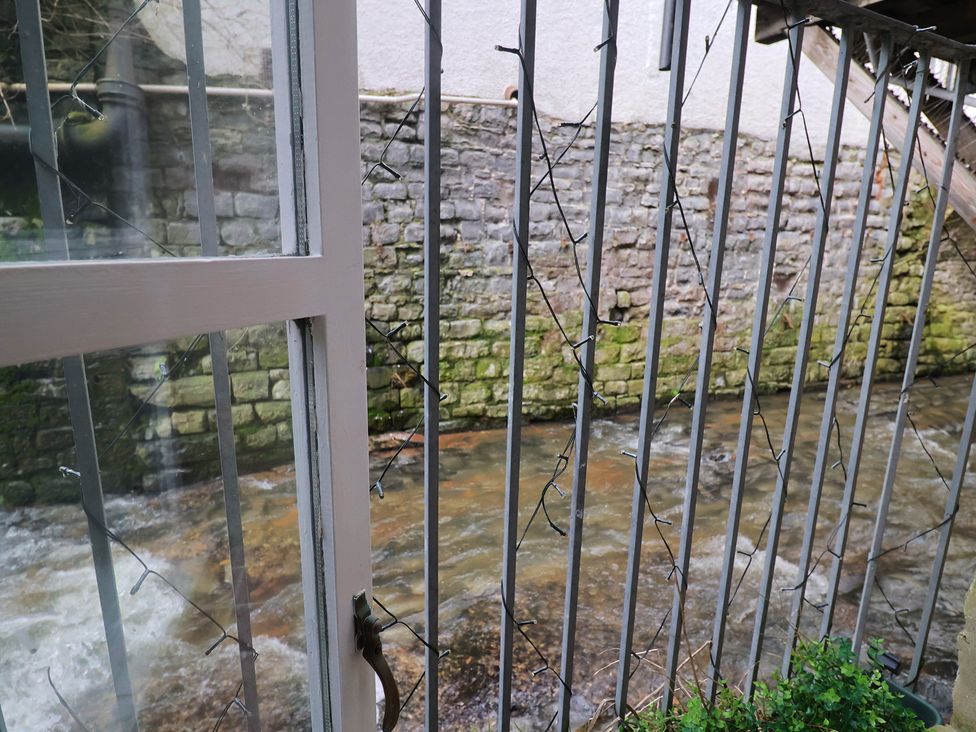 A view of a river through a railing at Riverdance Cottage in Lyme Regis