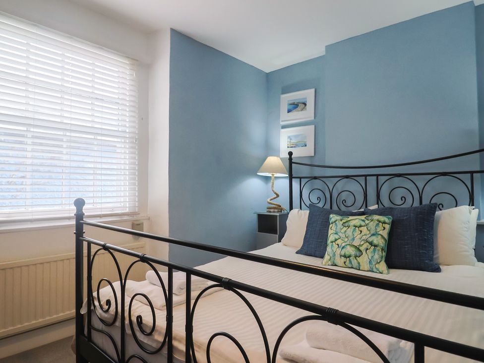 A bedroom with a bed and lamp at Riverdance Cottage in Lyme Regis