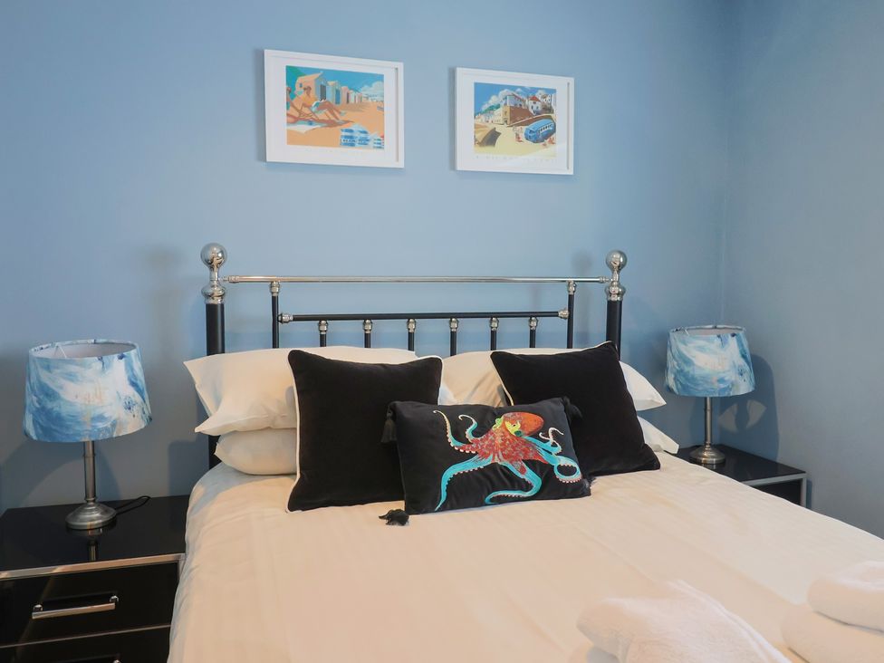 A bedroom with a bed and bedside lamps at Riverdance Cottage in Lyme Regis