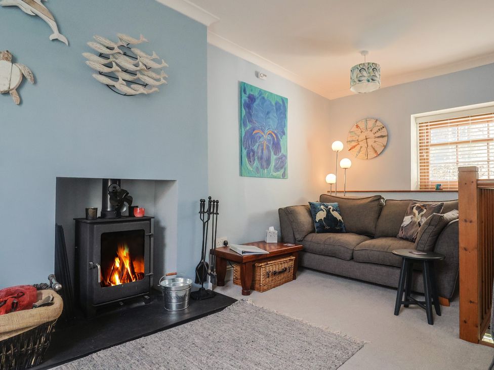 A living room with a sofa and fireplace at Riverdance Cottage in Lyme Regis