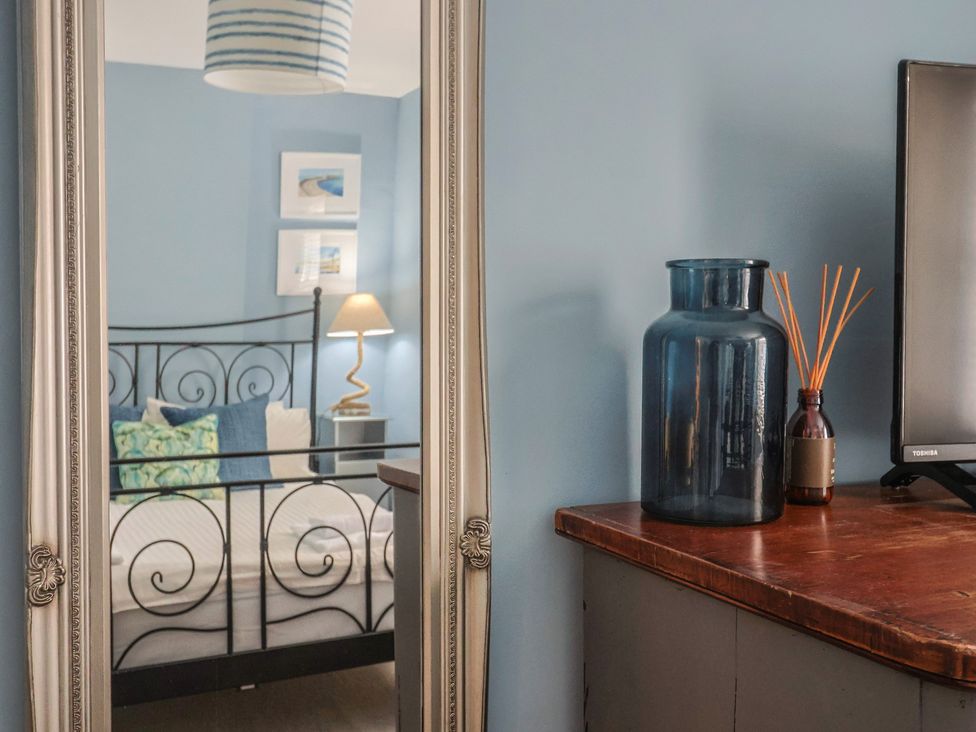A bedroom with a bed and decorative items at Riverdance Cottage in Lyme Regis
