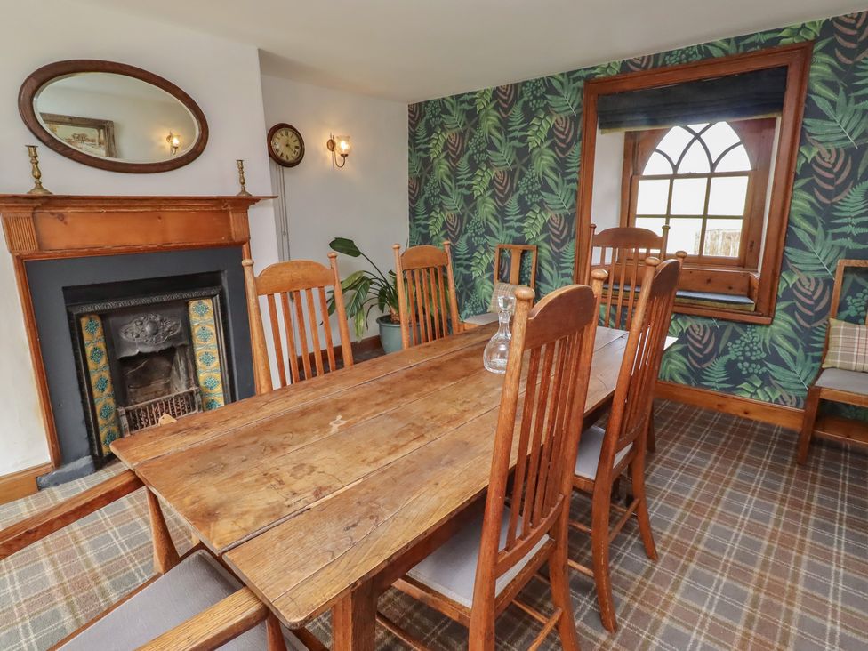 A dining room with a wooden table and chairs at The Coach House near Crookham-On-Tweed