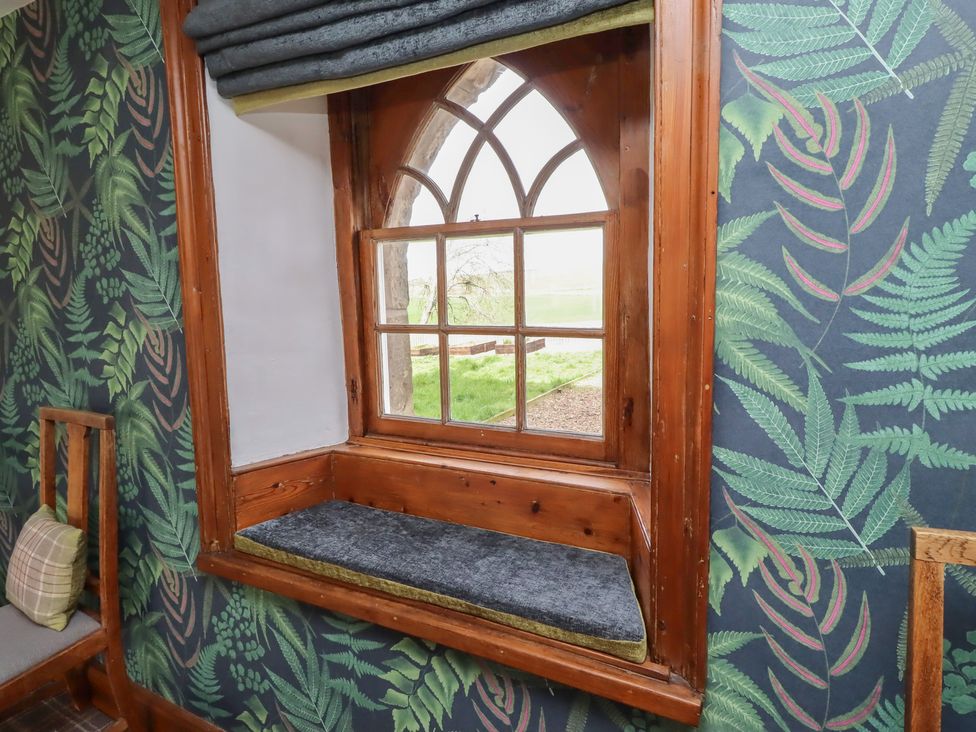 A window with a bench and a chair at The Coach House Crookham near Cornhill-On-Tweed