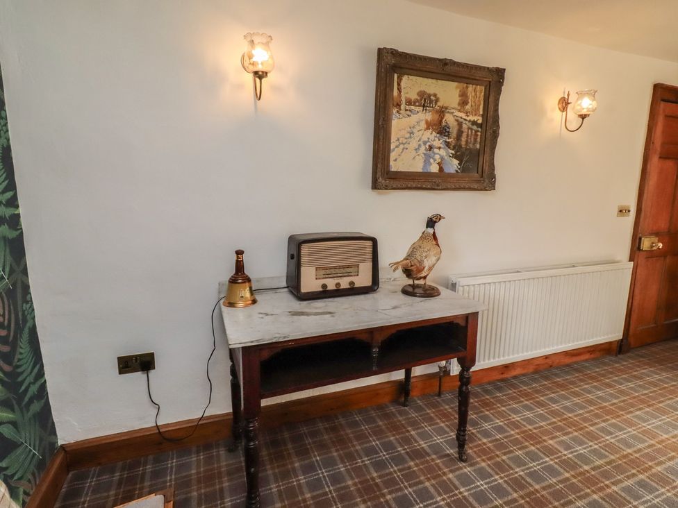 A snug room with a table and a radio at The Coach House Crookham near Cornhill-On-Tweed