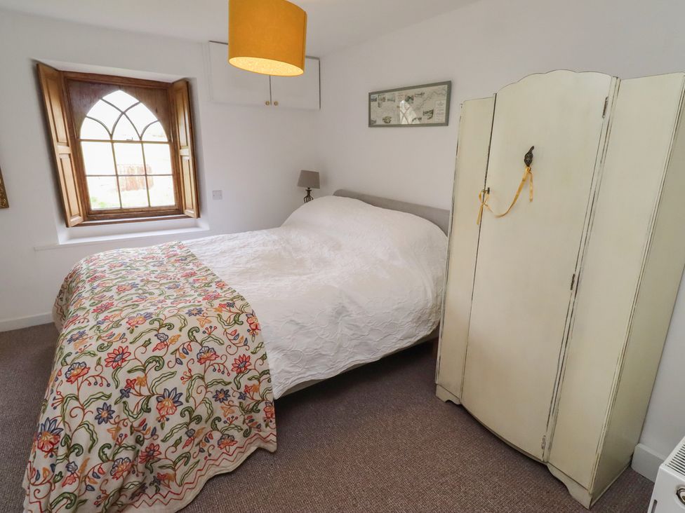 A bedroom with a bed and wardrobe at The Coach House Crookham near Cornhill-On-Tweed