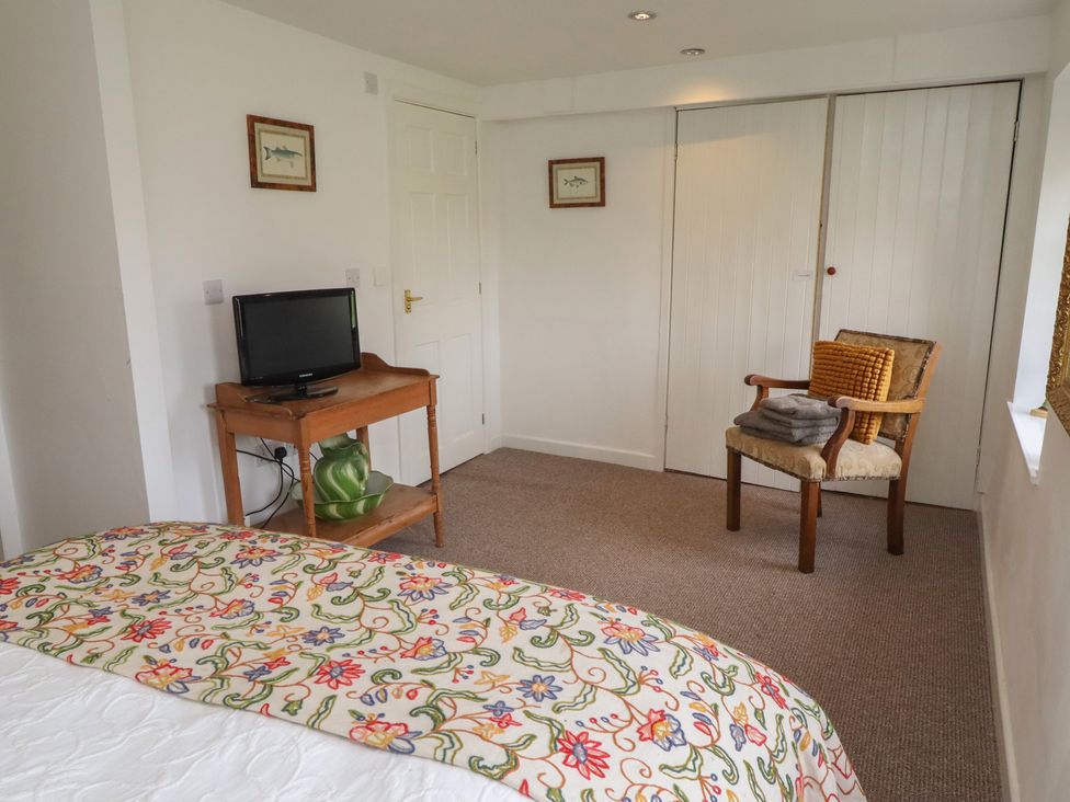 A bedroom with a bed and a television on a table at The Coach House Crookham near Cornhill-On-Tweed
