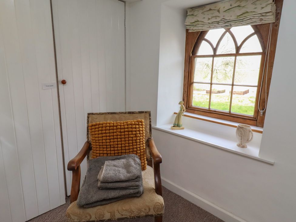 A chair with cushions and towels in a sitting room at The Coach House Crookham near Cornhill-On-Tweed