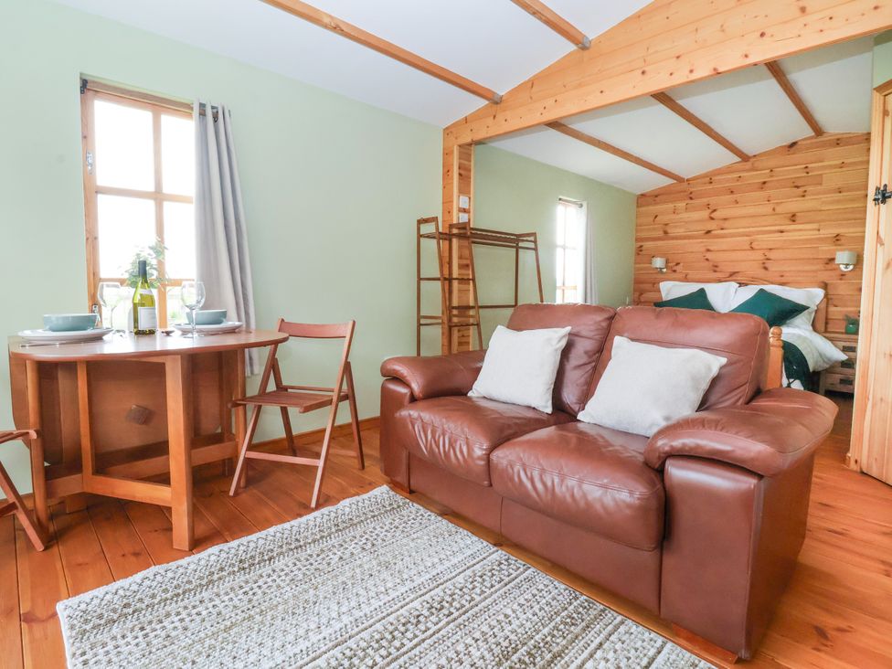 A living room with a couch and dining table at Lodge 1 in York