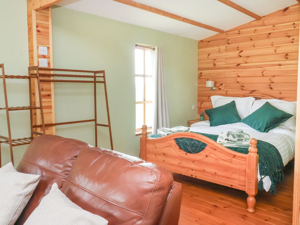 A bedroom with a bed and a sofa at Lodge 1 in York