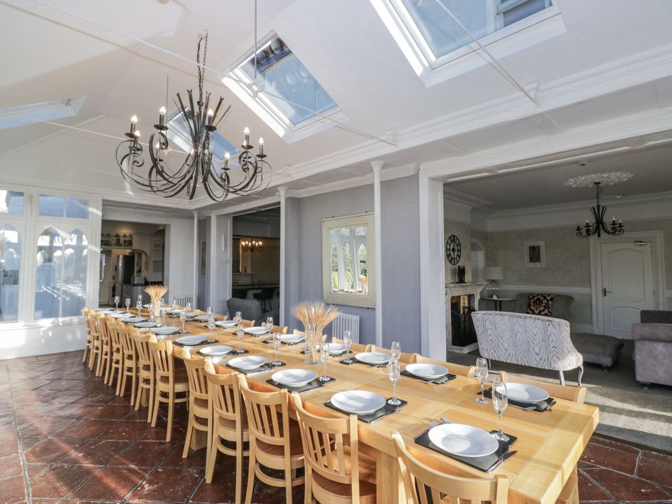 A dining room with a long table and chandelier at Valley View in Dalton-In-Furness