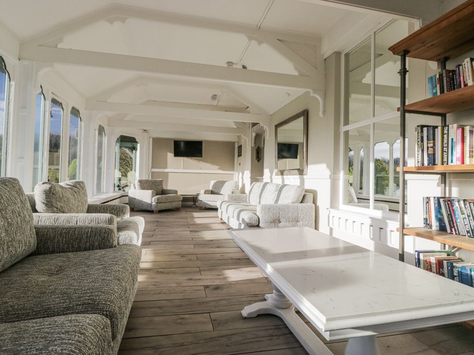 A conservatory with sofas and a TV at Valley View in Dalton-In-Furness