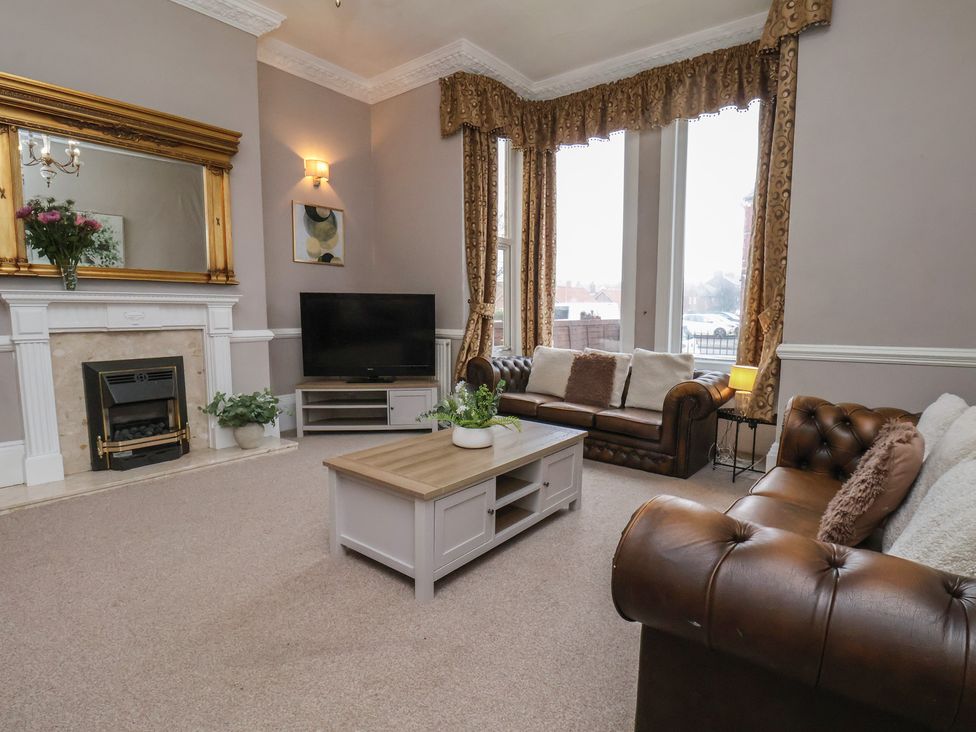 A living room with a sofa, coffee table, and television at Bridlington Bay House in Bridlington