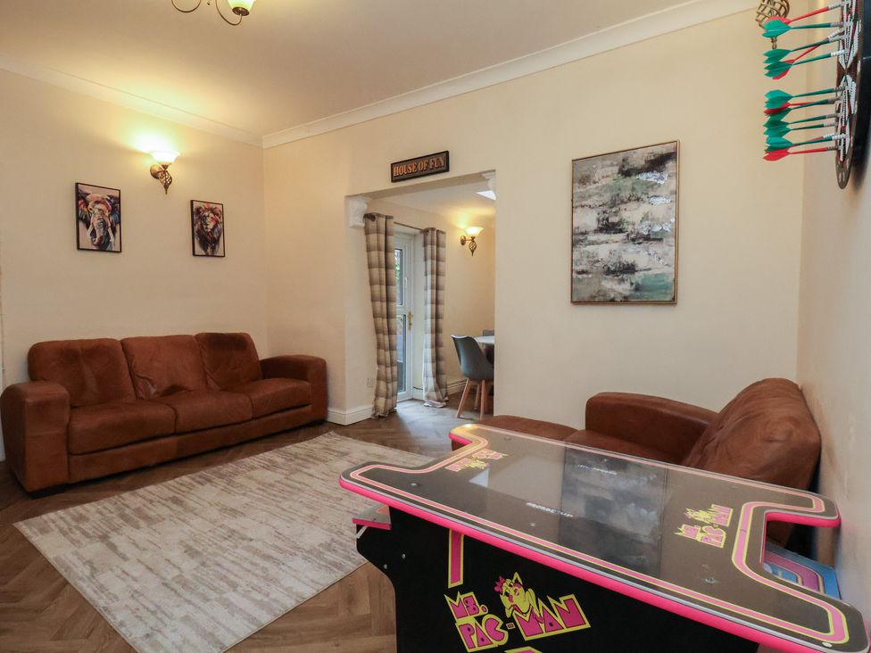 A living room with a sofa and arcade game at Bridlington Bay House in Bridlington