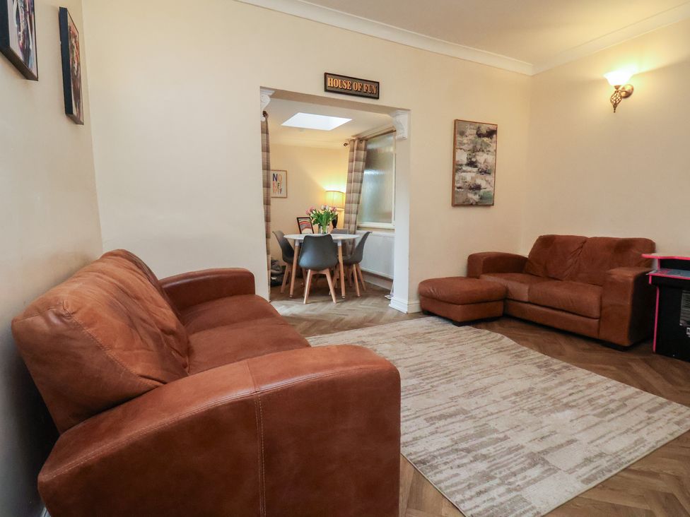 A living room with a sofa and doorway to dining area at Bridlington Bay House in Bridlington