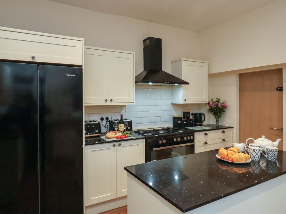 A kitchen with a refrigerator, stove, and sink at Bridlington Bay House in Bridlington