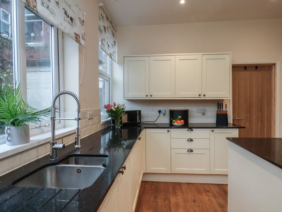 A kitchen with cabinets and a sink at Bridlington Bay House in Bridlington