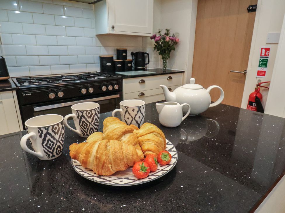 A kitchen with croissants and cups on the counter at Bridlington Bay House in Bridlington
