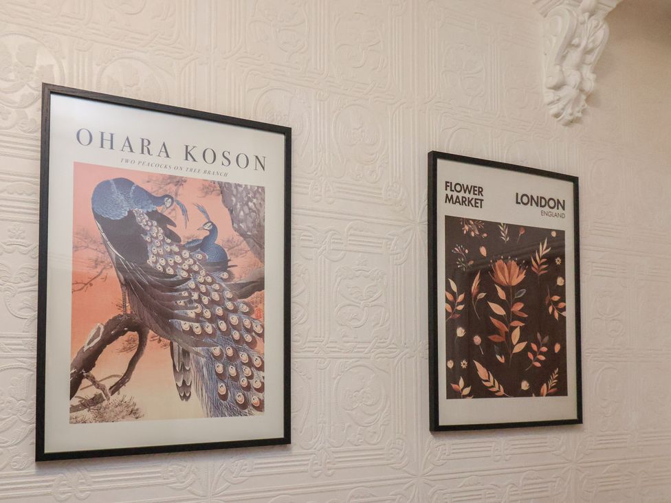 Framed prints on a wall featuring peacocks and flower market at Bridlington Bay House in Bridlington
