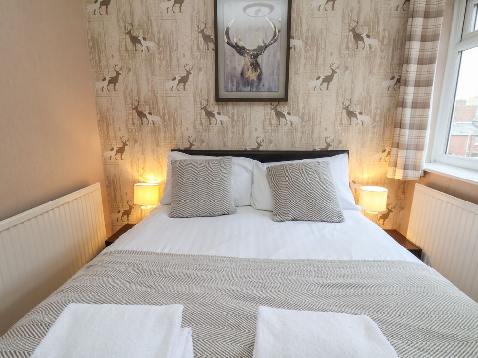 A bedroom with a bed and bedside lamps at Bridlington Bay House in Bridlington