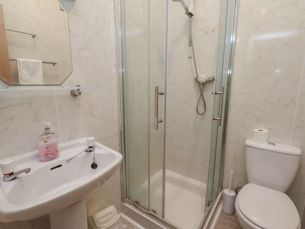 A bathroom with a shower, toilet, sink and mirror at Bridlington Bay House in Bridlington