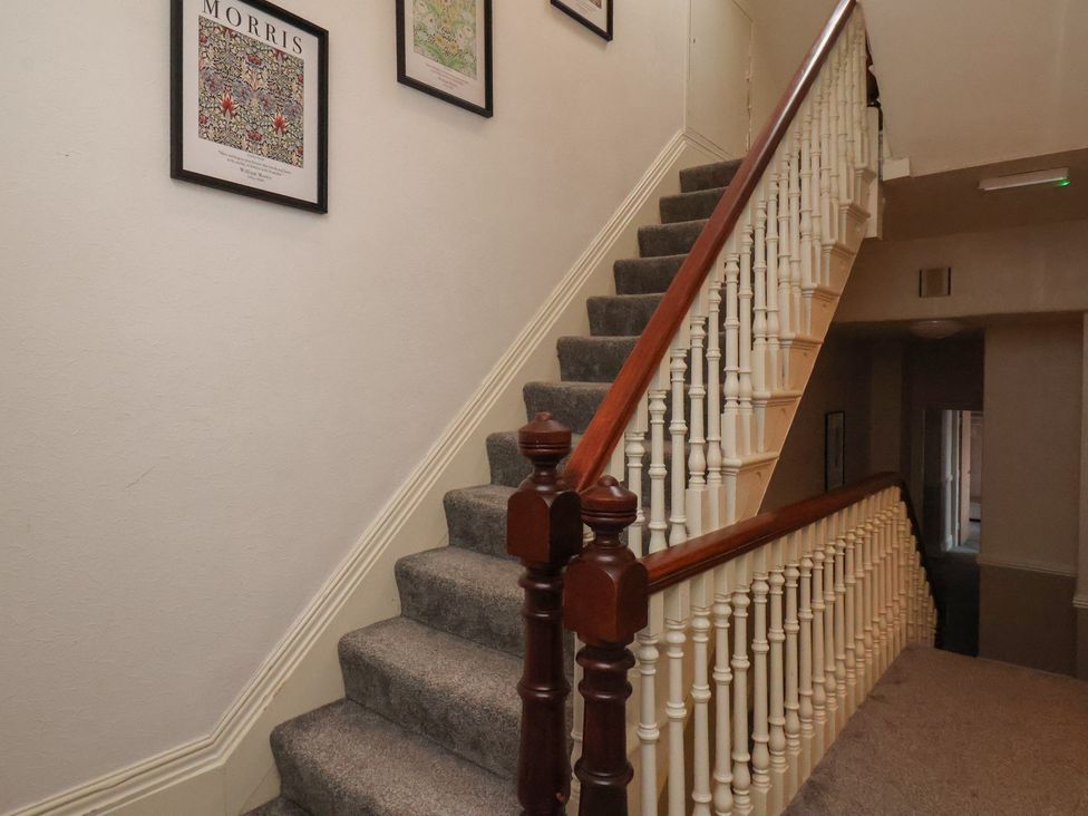 A staircase with artwork on the wall at Bridlington Bay House in Bridlington