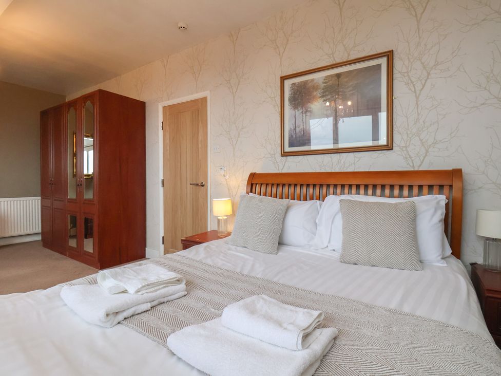A bedroom with a bed and wardrobe at Bridlington Bay House, Bridlington