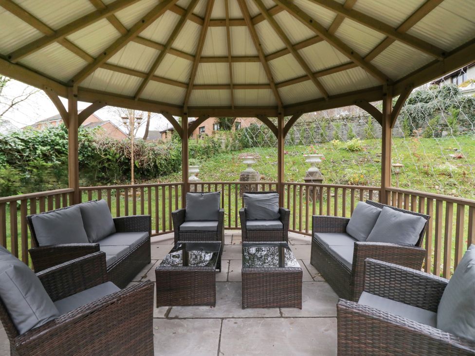 A gazebo with seating area in the garden at Beechgrove Manor in Workington