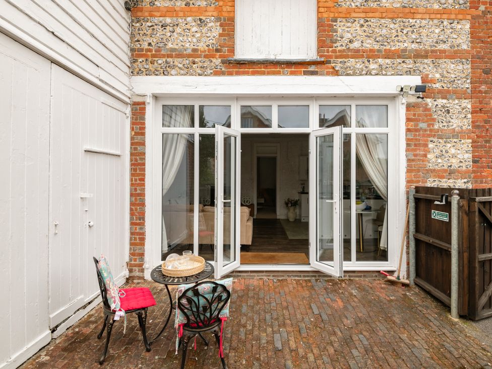 An outdoor area with furniture and French doors leading into a room at Primrose in Blandford Forum