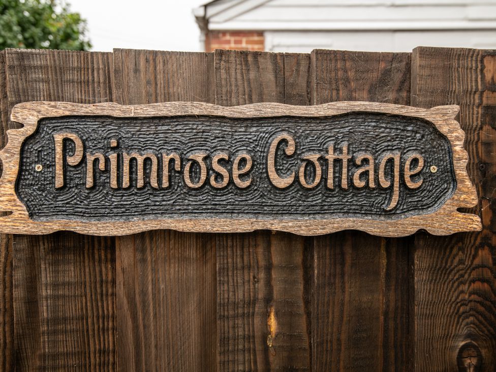 A wooden sign on a fence at Primrose Cottage in Blandford Forum