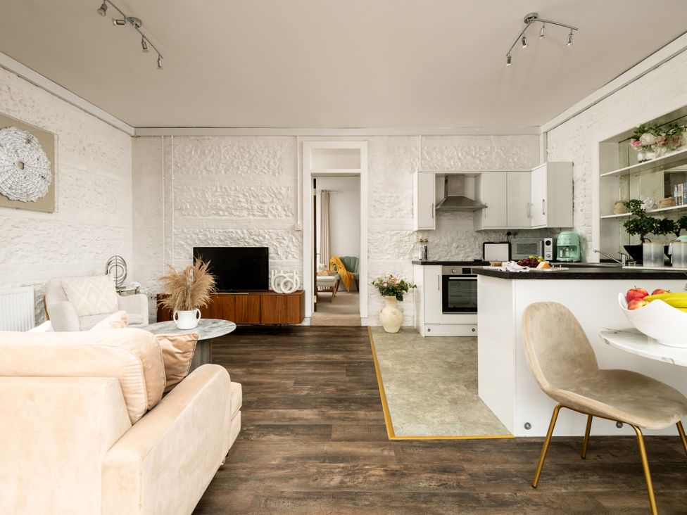 A living room with a television and kitchen area at Primrose in Blandford Forum