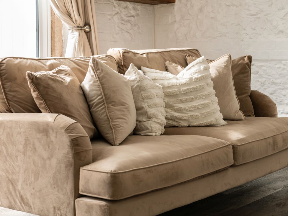 A sofa with cushions in a living room at Primrose in Blandford Forum