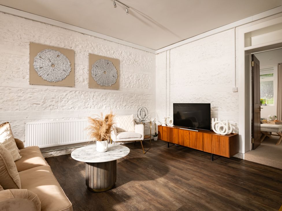 A living room with a sofa and a TV at Primrose in Blandford Forum