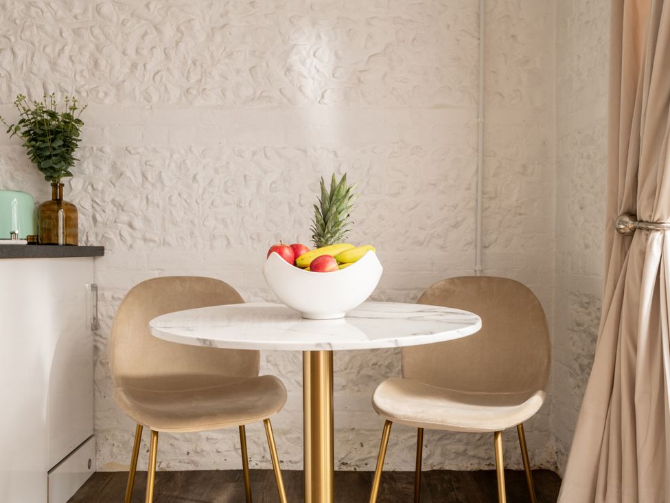 A kitchen with a table and chairs featuring a fruit bowl at Primrose in Blandford Forum