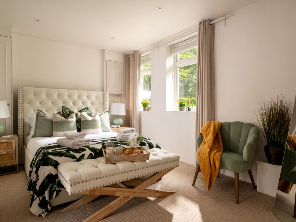 A bedroom with a bed and chair at Primrose in Blandford Forum