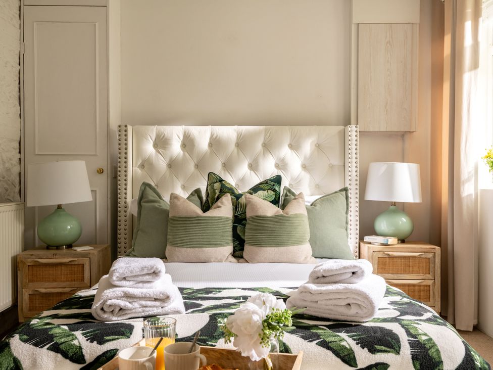 A bedroom with a bed and decorative items at Primrose in Blandford Forum