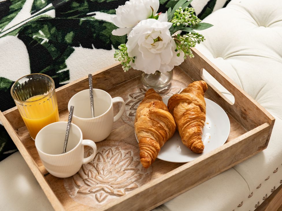 A tray with two croissants and cups in a living room at Primrose in Blandford Forum