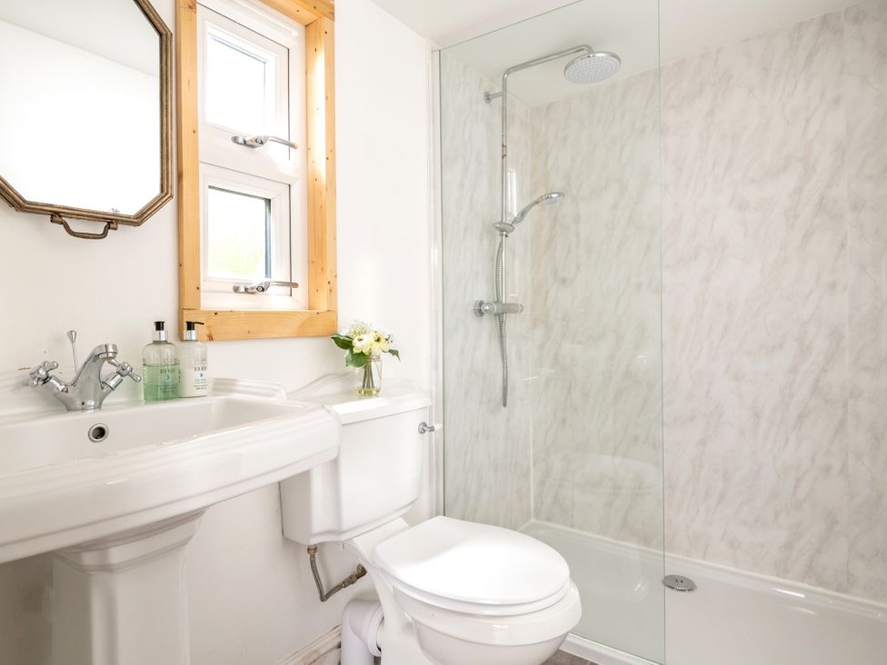 A bathroom with a shower, sink, and toilet at Hazel in Blandford Forum