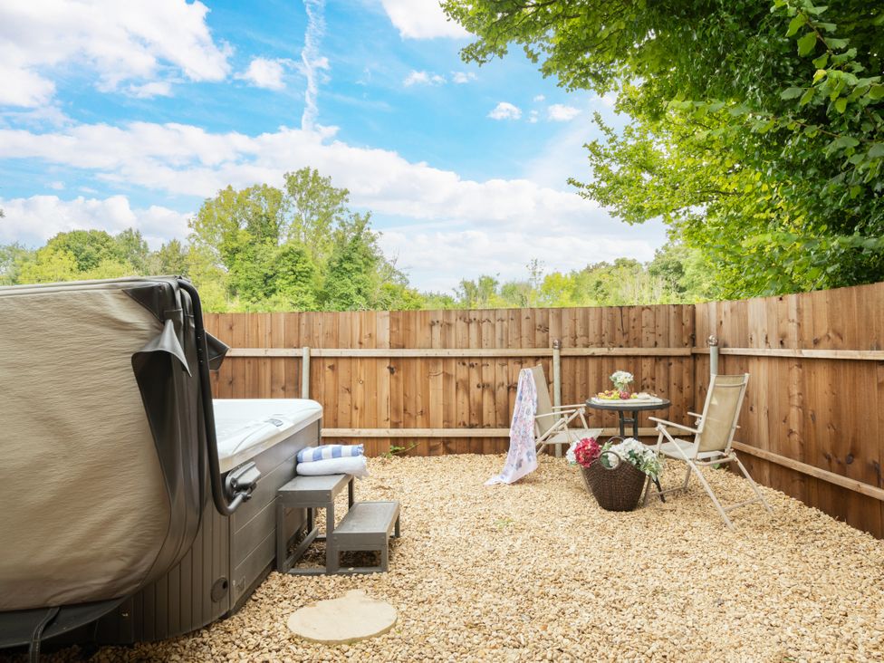 An outdoor area with a hot tub and seating at Hazel in Blandford Forum