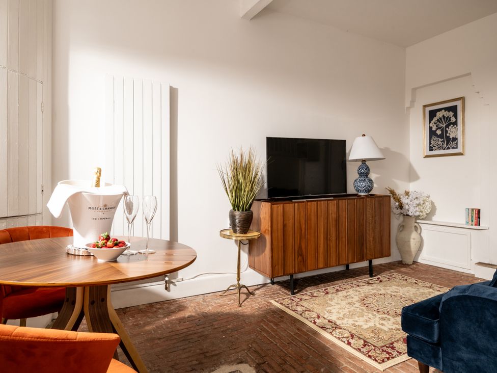 A living room with a television and a round table at Stable in Blandford Forum