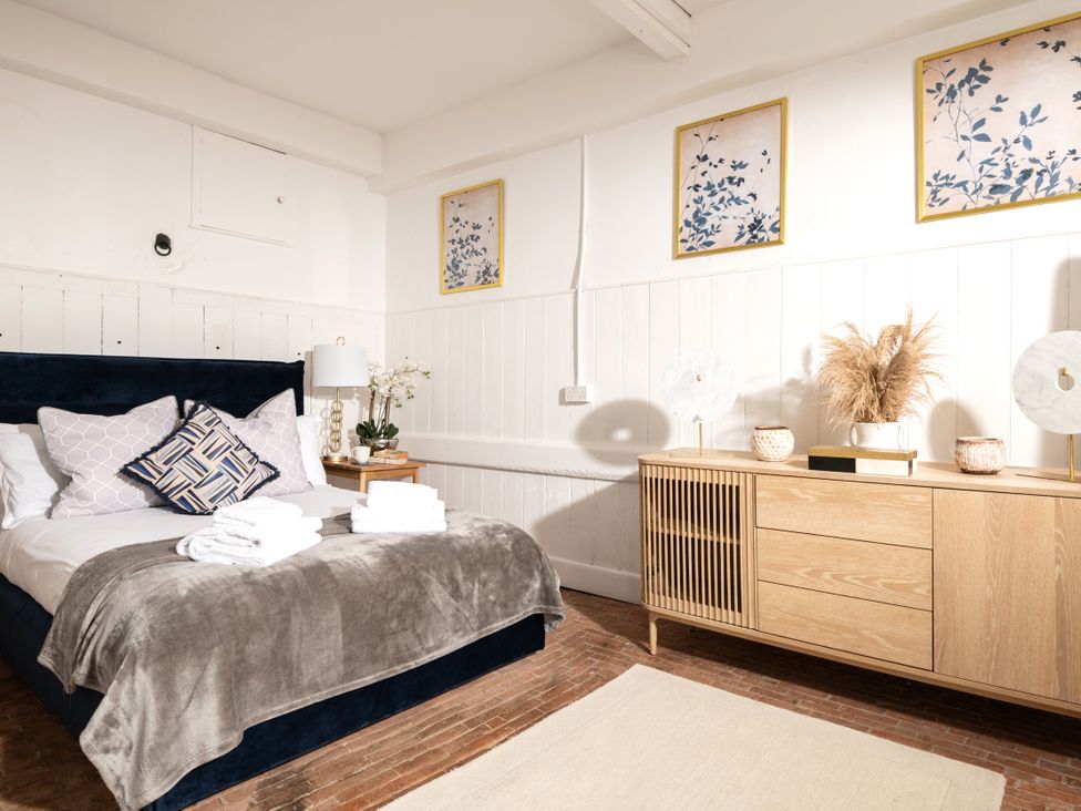 A bedroom with a bed and wooden storage cabinet at Stable in Blandford Forum