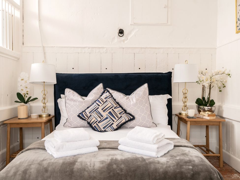A bedroom with a bed and pillows at Stable in Blandford Forum
